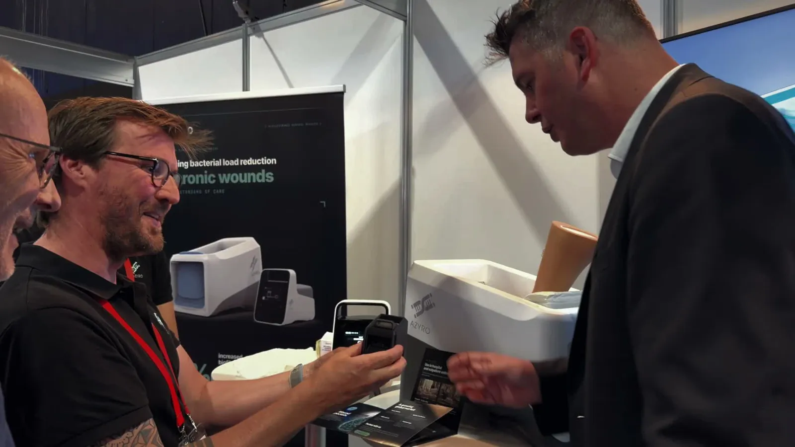 The Azyro team presenting the device to a visitor on its stand at Healthcare Week Luxembourg 2026.